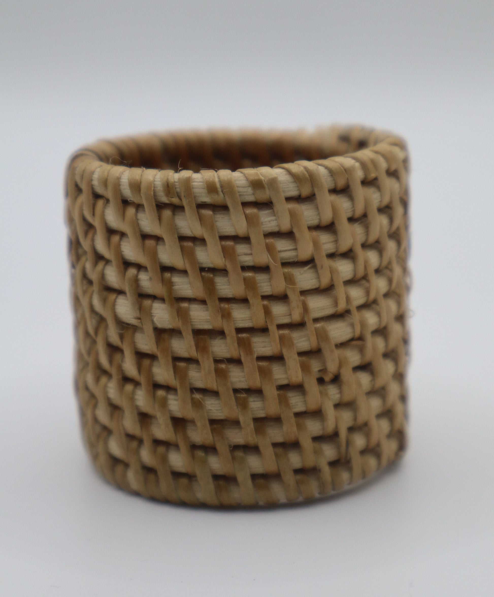 Woven brown napkin ring on a white background